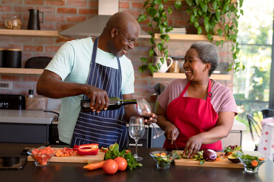Senior couple cooking together with a bottle of wine