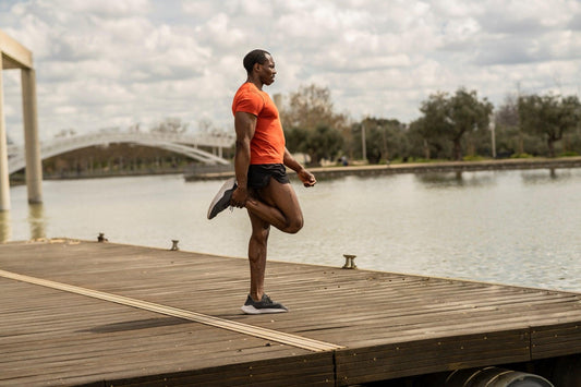 Senior man stretching by lake with cbd cream for seniors before workout